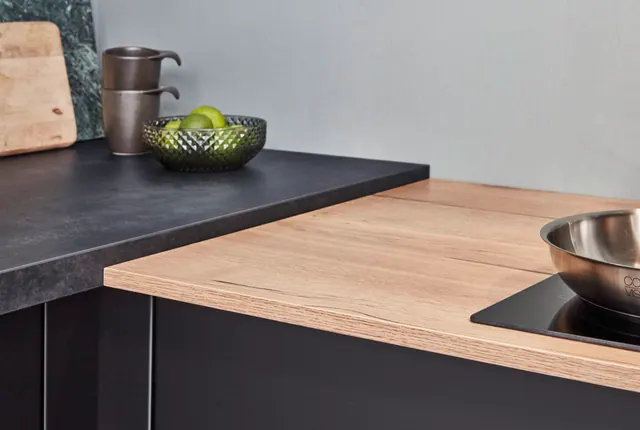 Černá kuchyň s dřevěnou deskou — detail kuchyně